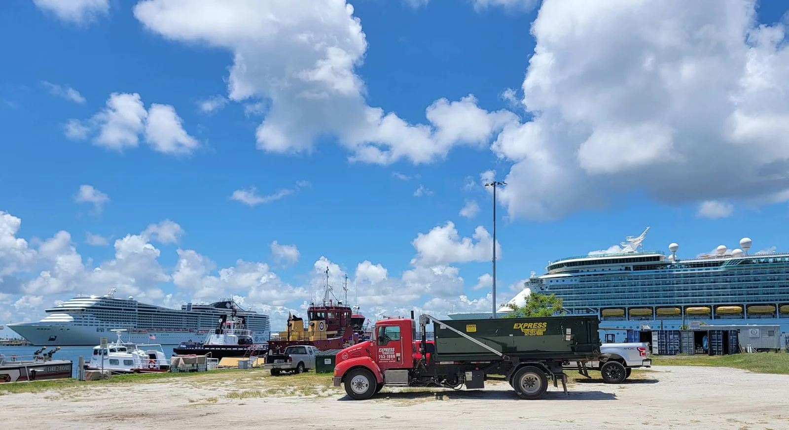 Retail renovation crew using roll off dumpster behind active shopping center during cleanup